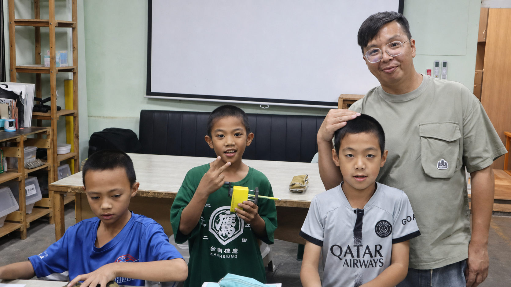 胡教練與三名孩子在室內合影